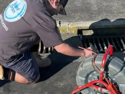 Speed Drain technician clearing a catchpit with a drain machine