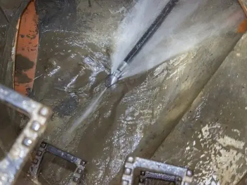 High-pressure water jet cleaning inside a drain